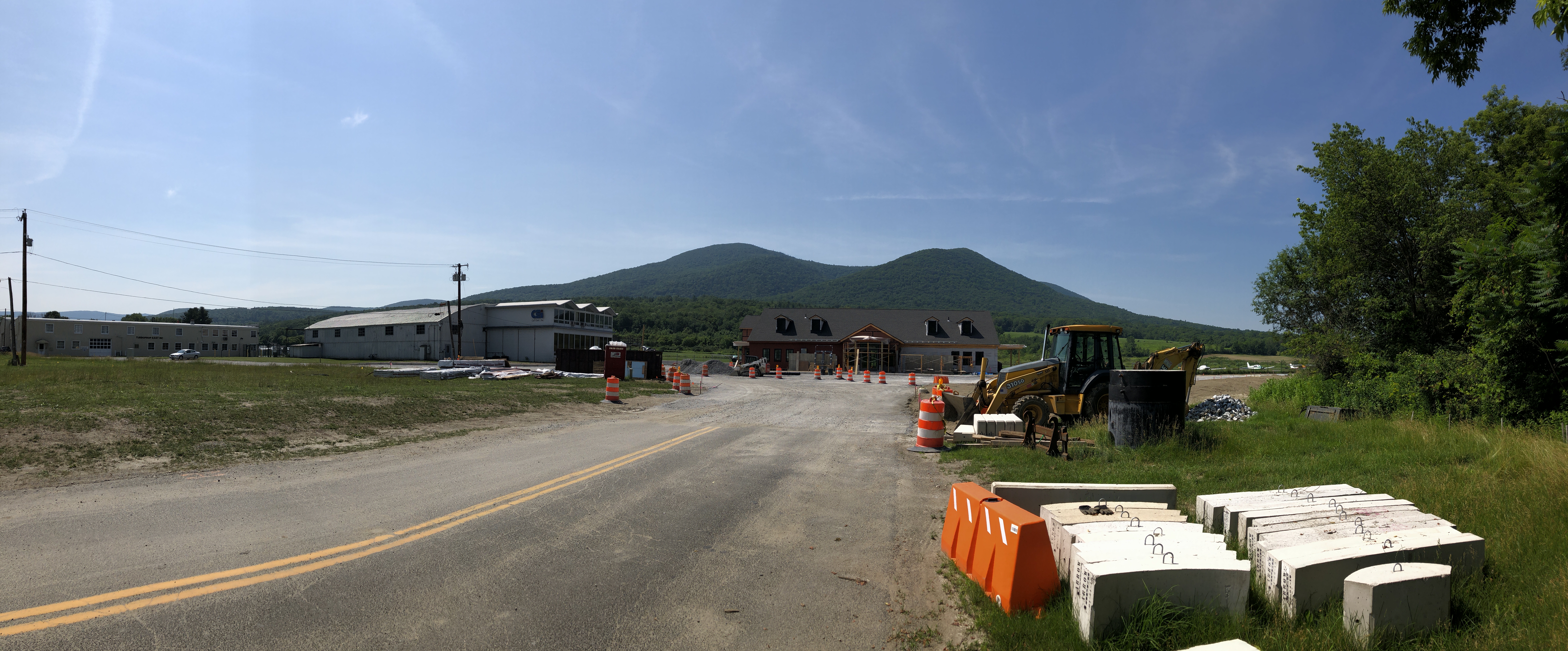 View from the airport's driveway.  A building is under construction in the center, with the mountain peaks beyond.