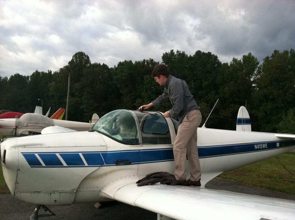 Pilot (the author) standing on the Ercoupe's wing, opening the canopy.